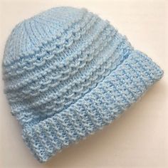 a light blue knitted hat on a white surface