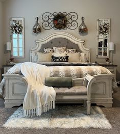 a bedroom with a large bed and white fur rugs on the carpeted floor