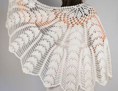 a woman wearing a white crochet shawl with an openwork design on it