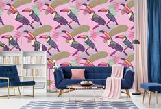 a living room with pink wallpaper and blue couches in front of a colorful touca