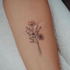 a small flower tattoo on the arm