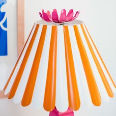 an orange and white lamp with a pink flower on it