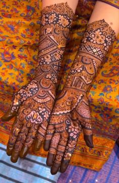 two hands with henna tattoos on them