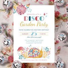 a disco garden party is set up on a table with silver ornaments and pink flowers