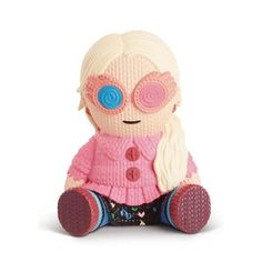 a small stuffed toy with big eyes and pink sweater on it's legs, sitting in front of a white background