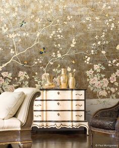 a white dresser sitting in front of a wall with flowers and birds painted on it