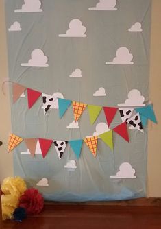 a bulletin board is decorated with colorful flags and clouds