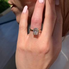 a close up of a person wearing a ring with a diamond on it's middle finger