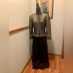 Nwot Landa Evening-Wear Jacket And Long Skirt, Size 10. Brocade Gold & Black Jacket With Beading Trim Around Collar, Hem And Down The Front. Long Back Skirt (45” From Waste To Hem) With Elasticized Back With Button & Zip Closure. Skirt Has Back Split. Skirt & Jacket 68% Terylene; 32% Chinlon. Skirt & Jacket Fully Lined 100% Terylene Professional Dry Clean Only One Bead Missing On Left Side Of Collar. (See Picture) Tailored Long Sleeve Sets For Evening, Elegant Winter Skirt Suit With Long Sleeves, Fitted Long Sleeve Evening Set, Elegant Long Sleeve Skirt Suit For Winter, Evening Long Sleeve Fitted Set, Evening Sets With Fitted Long Sleeve, Holiday Black Fitted Outerwear, Black Long Sleeve Skirt Suit For Formal Occasions, Fitted Evening Sets For Winter