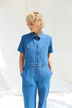 • Handmade in our studio from 98% cotton 2% spandex • Pointed shirt collar • Loose and relaxed fit with button placket at the front side • Interior waist with belt loops • Short sleeves • Chest pockets and two long patch pockets on the bottom • Available from XXS to XXL size or can be made in a custom size Denim Blue Short Sleeve Jumpsuit With Button Closure, Non-stretch Denim Jumpsuit With Short Sleeves, Relaxed Fit Denim Button-up Jumpsuit, Casual High-rise Denim Jumpsuit With Button Closure, Short-sleeve Denim Jumpsuit With Pockets, Short Sleeve Jumpsuit, Height Measurement, Womens Jumpsuits, Short Sleeve Jumpsuits