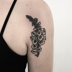 a black and white photo of a woman's shoulder with flowers on it