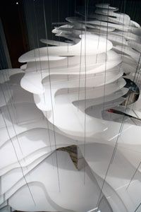 an art installation with white wavy lines and birds perched on the top of it,