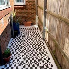 a black and white tiled patio with potted plants