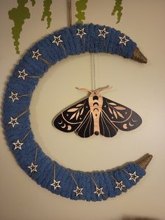 a moth is hanging on the wall next to a blue wreath with stars around it