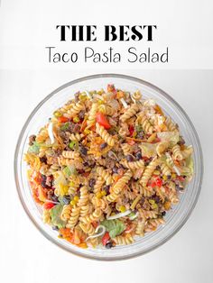 the best taco pasta salad in a glass bowl on top of a white table