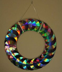 a multicolored circular hanging decoration made out of cd's on a wall