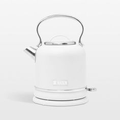 a white tea kettle sitting on top of a table