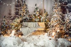 there is a bed in the middle of a pile of snow next to christmas trees