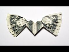 two origami butterfly wings made out of one hundred dollar bills on a white background