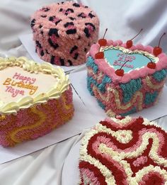 four birthday cakes sitting on top of each other in the shape of heart shaped cakes