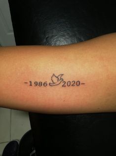 a person with a tattoo on their arm that reads, 1960 - 2020 written in cursive letters