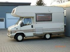 an rv parked in front of a garage