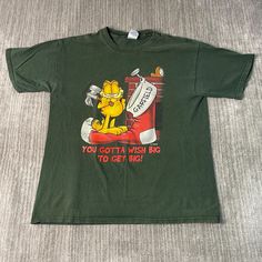 Vintage 2000s Garfield Cat Cartoon Christmas Humor Sayings Basic Essential Y2K Aesthetic Green Graphic T Shirt Large Mens Condition:  Fair Used Condition  = Fading On The Graphic Due To Age And Wear  Measurements: Please see photos above for all measurements IF YOU BUY TWO OR MORE ITEMS USE THE CODE BUNDLE @ CHECK TO SAVE 20% WE SHIP WITHIN 24 HOURS AFTER PURCHASE! Please be aware that we do not offer free returns!! The Buyer is responsible for the cost of the return label. Follow us on TikTok & Instagram @findsnostalgic and tag us in your finds Garfield Shirt Vintage, Y2k Short Sleeve Tops For Winter, Y2k Style Short Sleeve Tops For Winter, Christmas Streetwear Cotton T-shirt, Vintage Christmas Graphic Print T-shirt, Christmas Cotton T-shirt For Streetwear, Cotton Christmas T-shirt For Streetwear, Christmas Crew Neck Streetwear T-shirt, Christmas Crew Neck T-shirt For Streetwear