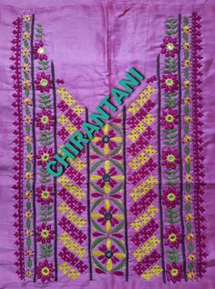 an embroidered purple cloth with green and yellow designs on the border, in front of a pink background