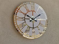 a clock with roman numerals on the face is shown in gold and silver