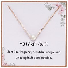 a card with the words you are loved on it and a pearl necklace attached to it