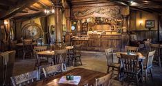 the inside of a restaurant with wooden tables and chairs, an old fashioned bar in the background