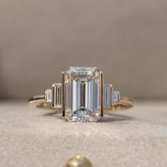 an emerald cut diamond ring with baguettes on the side