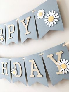 two happy birthday banners with daisies are hanging on the wall next to each other