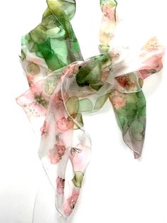 "Silk scarf hand painted pink, green \" Flowers dance \". Woman neck scarf hand painted on silk chiffon silk for SilkStory scarves collection. Delicate pink decorative flowers fit nicely on a white background. The green mossy color of the leaves gives the scarf integrity and the completeness of the composition. Various decorative floral and leaves patterns create a natural feeling of nature. This scarf is painted on fine 100% pure silk (chiffon), and is hand hemmed with silk threads. Size: 18x72 Pink Hand Painted Silk Scarves, Pink Hand-dyed Scarf, Handmade Pink Silk Scarf, Hand Painted Pink Silk Scarf For Gift, Pink Hand Painted Silk Scarf As Gift, Handmade Pink Silk Scarves, Hand Painted Pink Silk Scarf Gift, Pink Hand Painted Silk Scarf Gift, Pink Artistic Scarves For Summer