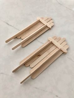 three popsicle sticks sitting on top of a white marble counter next to each other