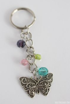 a butterfly shaped keychain with multicolored beads on it's side