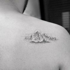 a black and white photo of a man with a mountain tattoo on his upper back