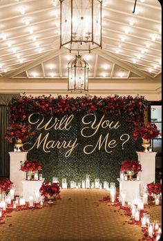 a wedding ceremony with candles and flowers on the aisle, which says will you marry me?