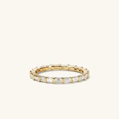 an 18k gold band with baguettes set in the middle and two diamonds on each side