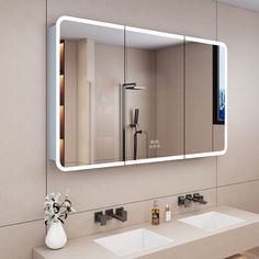 a bathroom with two sinks and a large mirror above the sink that has lights on it