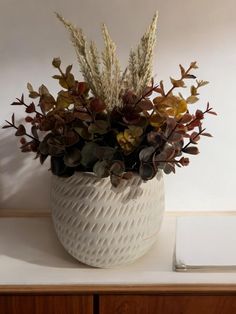 a white vase filled with flowers on top of a table