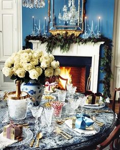 a dining room table set for christmas dinner with white roses and candy canes on it