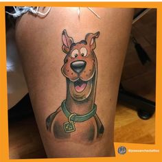 a cartoon dog tattoo on the leg