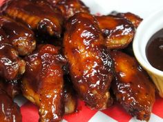 chicken wings and dipping sauce on a red and white checkered tablecloth