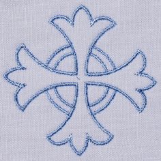 an embroidered cross with blue thread in the center on a white cloth textured background