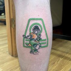 a person with a green and yellow tattoo on their leg