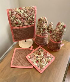 four pieces of fabric sitting on top of a wooden table next to pillows and place mats