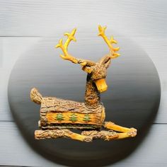 a wooden sculpture of a deer with antlers on it's back