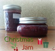 two jars filled with jam sitting on top of a table next to a christmas present