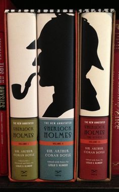 the silhouettes of three books are on top of each other in front of red bookshelves